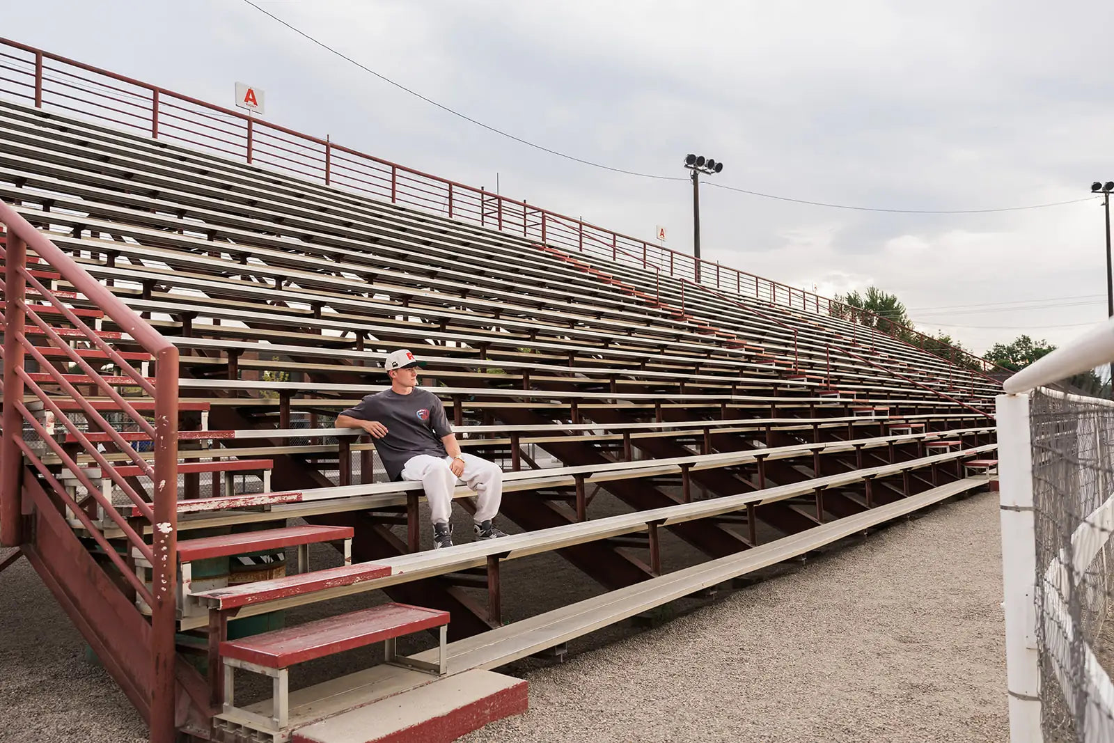 Empty rodeo grandstand at dusk, Croma R cap and wave tee